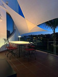 ein Tisch und Stühle auf einem Balkon in der Nacht in der Unterkunft Mirador at Island Resort in Sitio de Calahonda