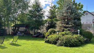 a yard with chairs and trees and a gazebo at Cabana Rustic Bran in Bran