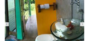 a glass bowl in a bathroom with a toilet at The Orange House in Big Corn Island
