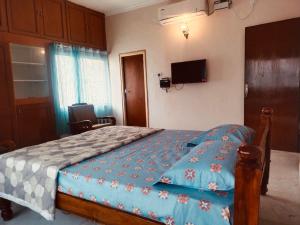 a bedroom with a bed and a tv on the wall at Egmore P V Cherian Road 4bhk in Chennai +12 photos