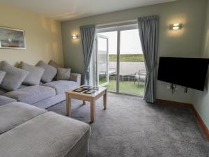 a living room with a couch and a tv at Sea Spray in Caernarfon