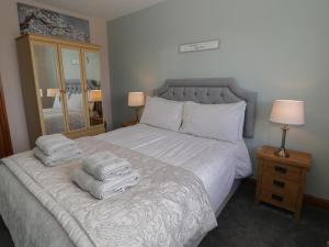a bedroom with a bed with towels on it at Sea Spray in Caernarfon