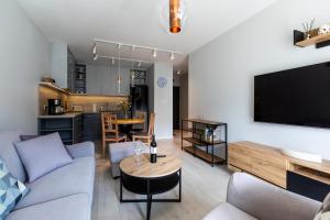 a living room with a couch and a table at Lotos Spa by Major Domus Club in Dziwnów