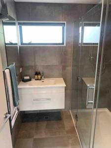a bathroom with a sink and a shower at New State Of The Art Sunny Warm free Park in Christchurch