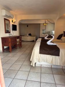Cama ou camas em um quarto em Hotel Hacienda María Eugenia Acapulco