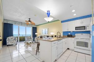 a kitchen with white appliances and a dining room at Luxury 11th Floor 1 BR Condo Direct Oceanfront Wyndham Ocean Walk Resort Daytona Beach | 1105 in Daytona Beach