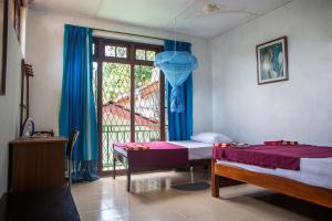 Un pat sau paturi într-o cameră la Araliya Holiday Bungalow