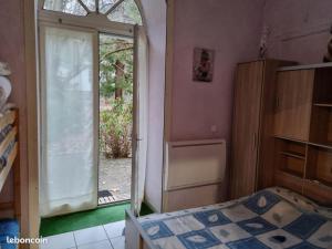 una camera da letto con un letto e una porta scorrevole in vetro di Appartement de plain pied , jardin et grande terrasse a Ussat