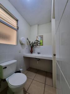 een witte badkamer met een toilet en een wastafel bij Mazaryk Bed and Breakfast in Antigua Guatemala +11 foto's