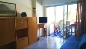 a room with a bedroom with a dresser and a television at Casa Margot in Sanremo