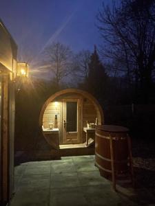 a small wooden sauna with a tub in the dark at Lacuna VITA by Sonnevijver Residences in Lanaken +15 photos