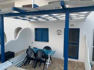 a patio with a blue table and chairs at Right on the beach- BEACHFRONT-Best unit -Paros in Aliki