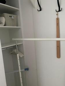 a closet with white shelves and a baseball bat at Smart Residence in Baia Mare