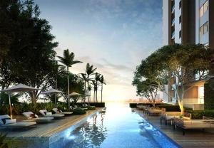 a hotel with a swimming pool with chairs and umbrellas at Sea View Spacious Condo At Pattaya in Pattaya Central