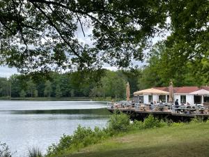 a dock with tables and chairs next to a lake at Lacuna VITA by Sonnevijver Residences in Lanaken