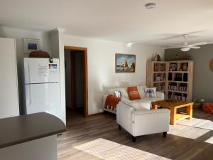 a living room with a white couch and a table at Lazy Sails Port - Pets welcome inside WiFi in Robe