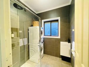 a bathroom with a refrigerator and a sink and a window at D139 Norfolk Cottage Stay in Maribyrnong +39 photos