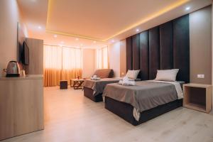 a hotel room with two beds and a flat screen tv at Tim Apartmani in Ohrid