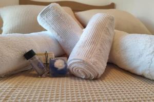 two white towels and a candle on a bed at S & d loft in Heraklio
