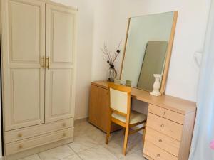 a desk with a mirror and a chair in a room at Skopelos Inn in Stafylos