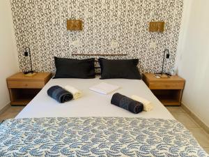a bedroom with a bed with two night stands and two tables at Skopelos Inn in Stafylos