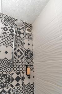 a bathroom with black and white tiles and a ladder at Hotel Argos in Vendenheim