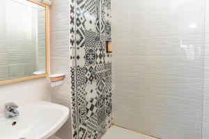 a bathroom with a sink and a shower at Hotel Argos in Vendenheim