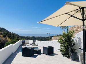 eine Terrasse mit Tisch und Sonnenschirm in der Unterkunft Casa Paraiso en Frigiliana in Frigiliana