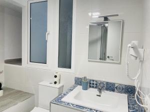 ein weißes Badezimmer mit Waschbecken und Spiegel in der Unterkunft Casa Paraiso en Frigiliana in Frigiliana