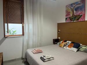 a bedroom with a bed with two towels on it at Green House in Avola