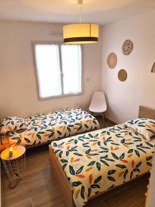 a bedroom with two beds and a lamp at La Riviera - Site du Futuroscope - 3 chambres in Chasseneuil-du-Poitou +24 photos