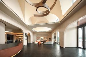 a lobby with a ceiling with a chandelier at Atour Hotel Shanghai Lingang Wanda Plaza in Pengsan