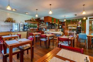 a restaurant with tables and chairs in a room at Hotel Restaurant Argos, Strasbourg Nord in Vendenheim