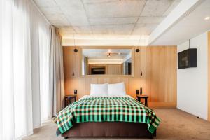 una camera da letto con un letto con una coperta verde e bianca di Skostredet Hotel & Spa a Bergen