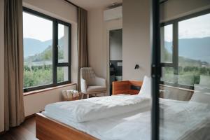 a bedroom with a bed and a window and a chair at Garni-Hotel Der Forsterhof in Lagundo +97 photos