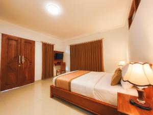 a bedroom with a bed and a lamp in it at Rostika Hotel Sekumpul in Pabean Buleleng