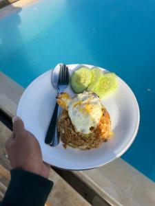 a person holding a white plate with food on it at Pinggan Foggy in Baturaja