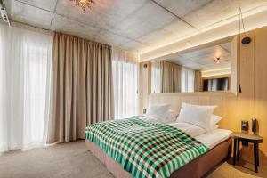 a bedroom with a bed with a checkered blanket at Skostredet Hotel & Spa in Bergen