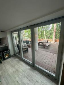 sala de estar con puertas correderas de cristal y patio en Domek Letniskowy Villa, en Konarskie