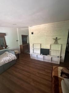 Un dormitorio con una cama y una pared de madera. en Domek Letniskowy Villa, en Konarskie