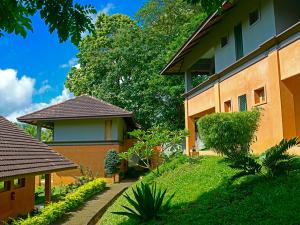 a house with a pathway next to a building at Abad Green Forest Thekkady in Thekkady