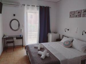 a bedroom with a bed with towels on it at Hotel Liliana in Agia Marina Aegina