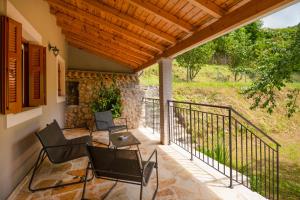 a patio with chairs and a wooden roof at Galini Vines - Authentic Corfu village life WiFi AC in Petáleia