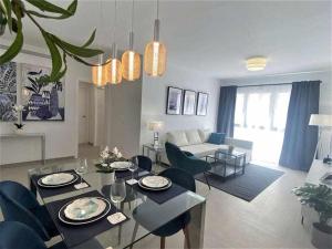 a living room with a table and chairs and a couch at XV Apartamentos Morales & Arnal in Estepona