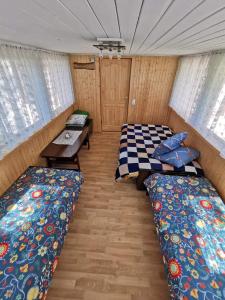 a room with two beds and a table in a trailer at Sodyba pas Babą - namas KLASIKA in Palanga