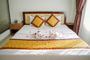two stuffed animals sitting on top of a bed at Bu Hotel Thành Phố Huế in Thôn Lại Thê