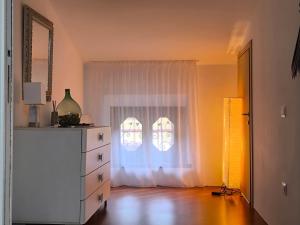a room with a white window and a dresser at Villa Riva Lago - Apartment with garden and parking in Tavernola Bergamasca