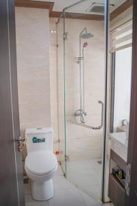 a bathroom with a toilet and a glass shower at Bu Hotel Thành Phố Huế in Thôn Lại Thê