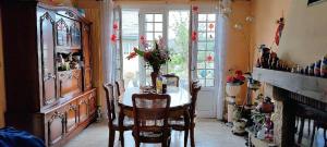 a dining room with a table and chairs and a fireplace at Chambre dans maison individuelle avec rez-de-chaussée partagé - cuisine, salle, salon et salle de bains in Saint-Brieuc