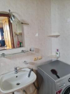 a bathroom with a sink and a mirror and a toilet at House Anna in Gonio